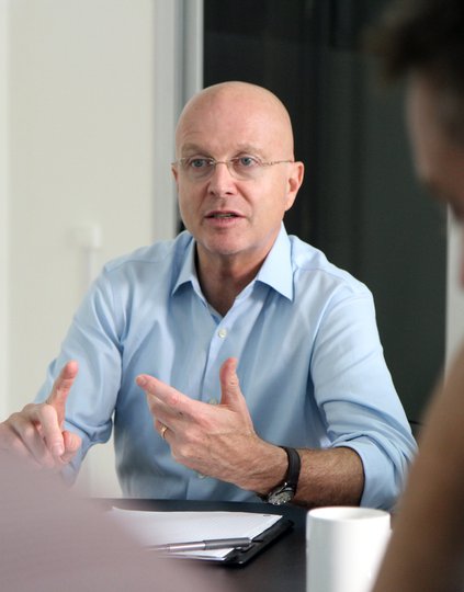 Steve Davis gesturing and speaking with colleagues.