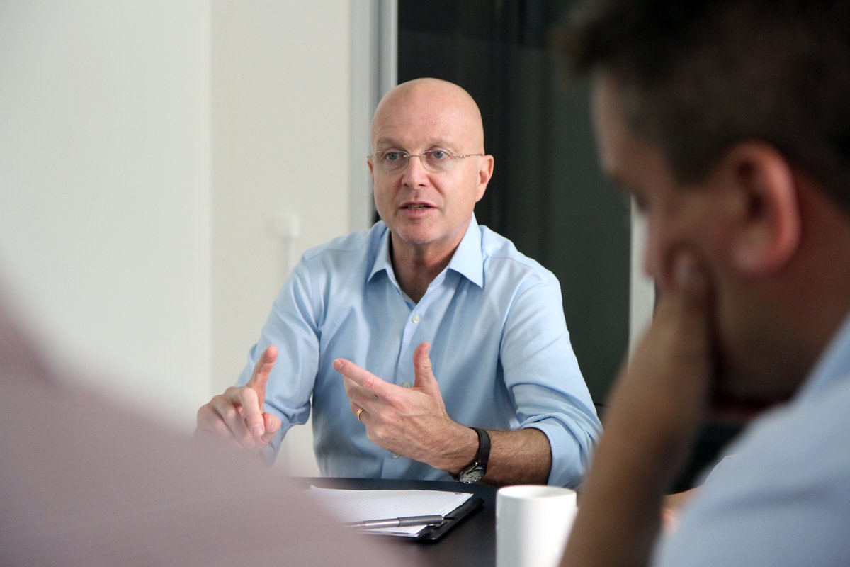 Steve Davis gesturing and speaking with colleagues.