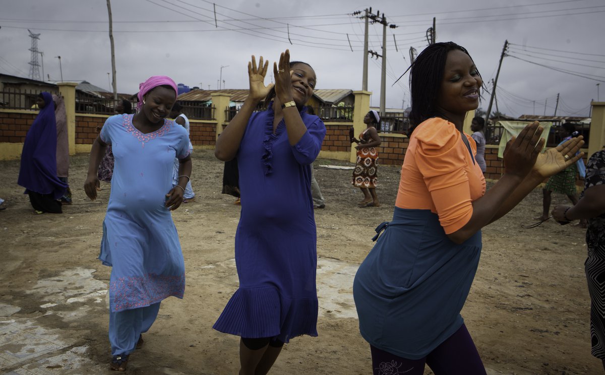 Pregnant women exercise outside the Lugbe Primary Heath Care Center at the start of antenatal clinic. Abuja, Africa