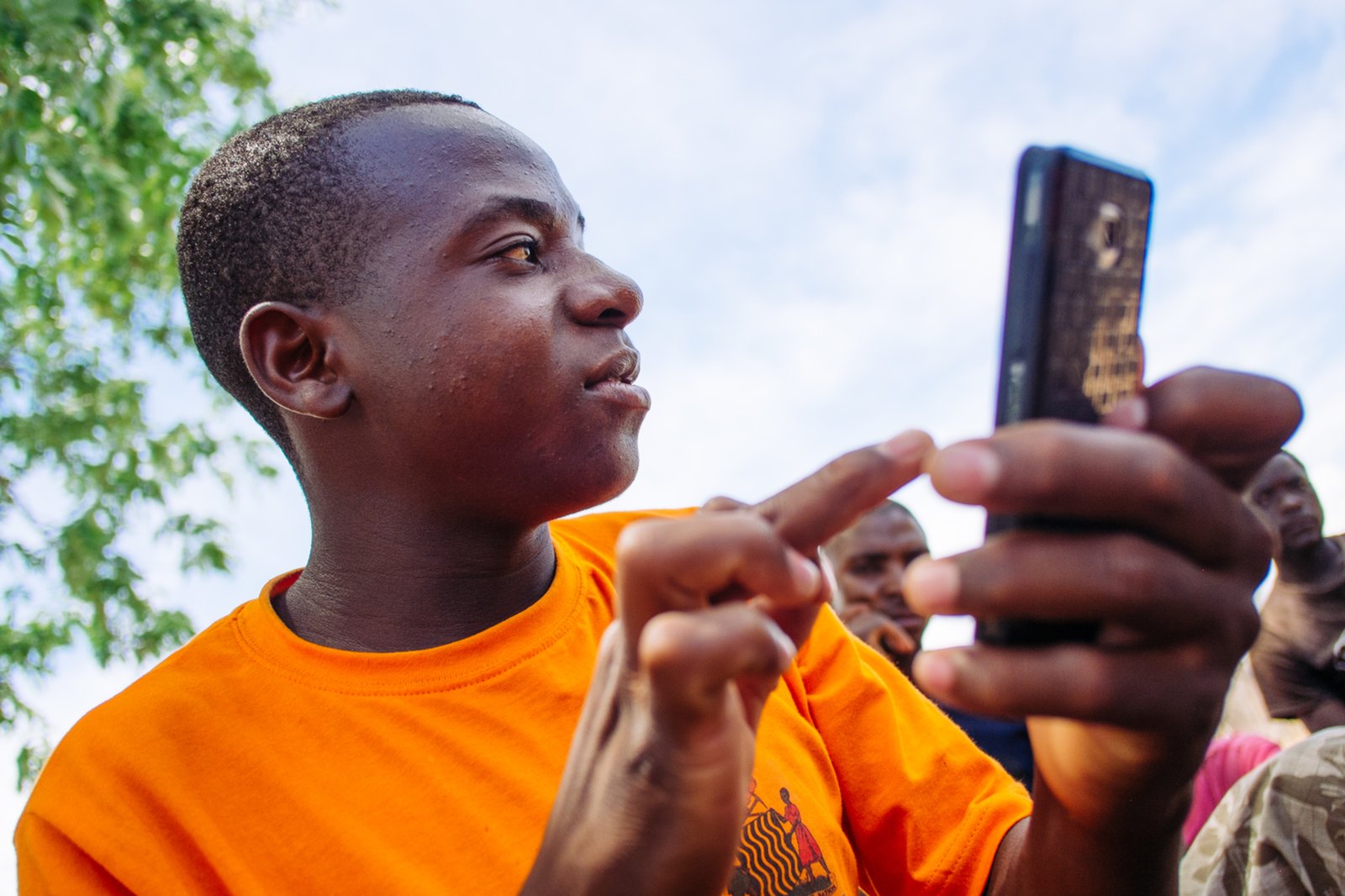 In Sinafala village Zambia, data collector Odinga Chitonka, touches the screen of his mobile phone