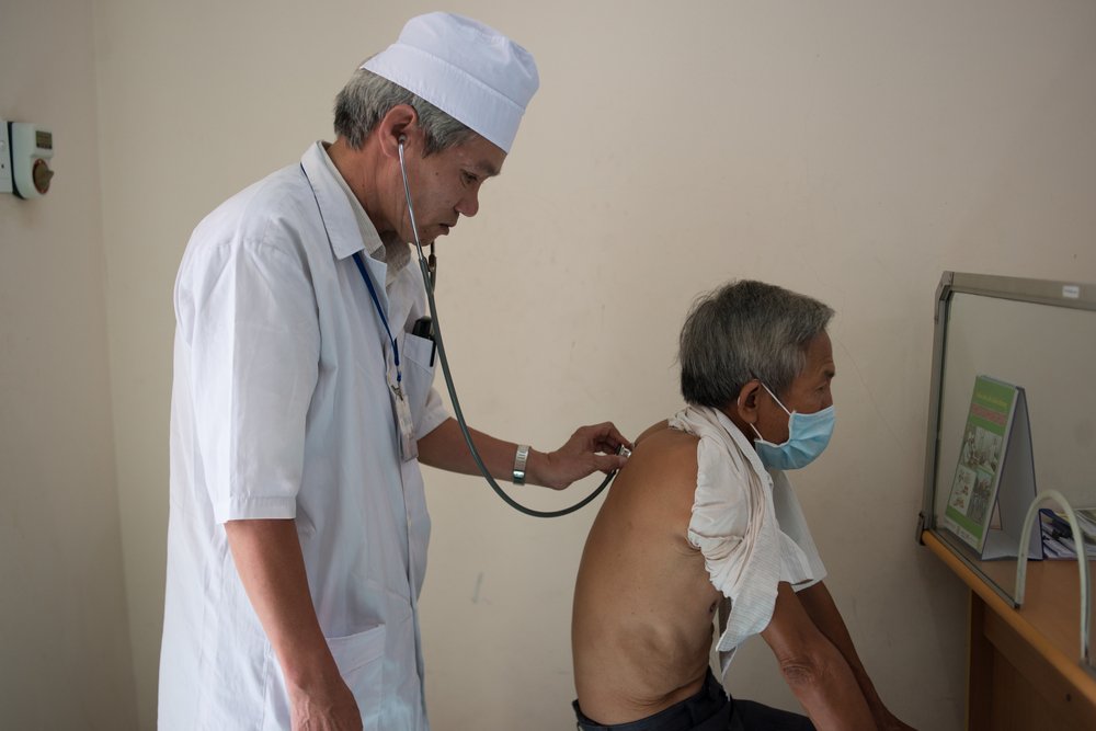 A health care worker examining a TB patient at the Chuong My District Health Center in Vietnam. Photo: PATH/Matthew Dakin.