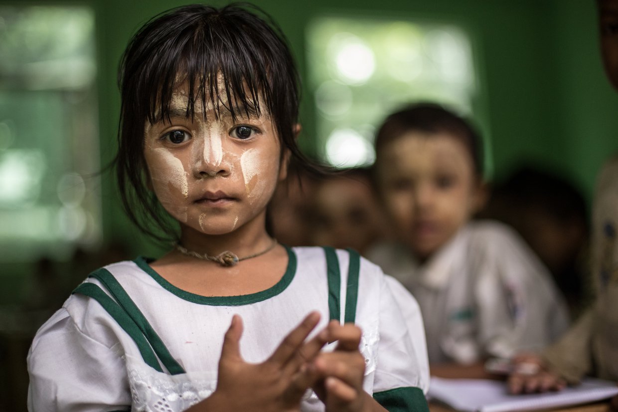 Schoolgirl with traditional thanaka paste on her face.