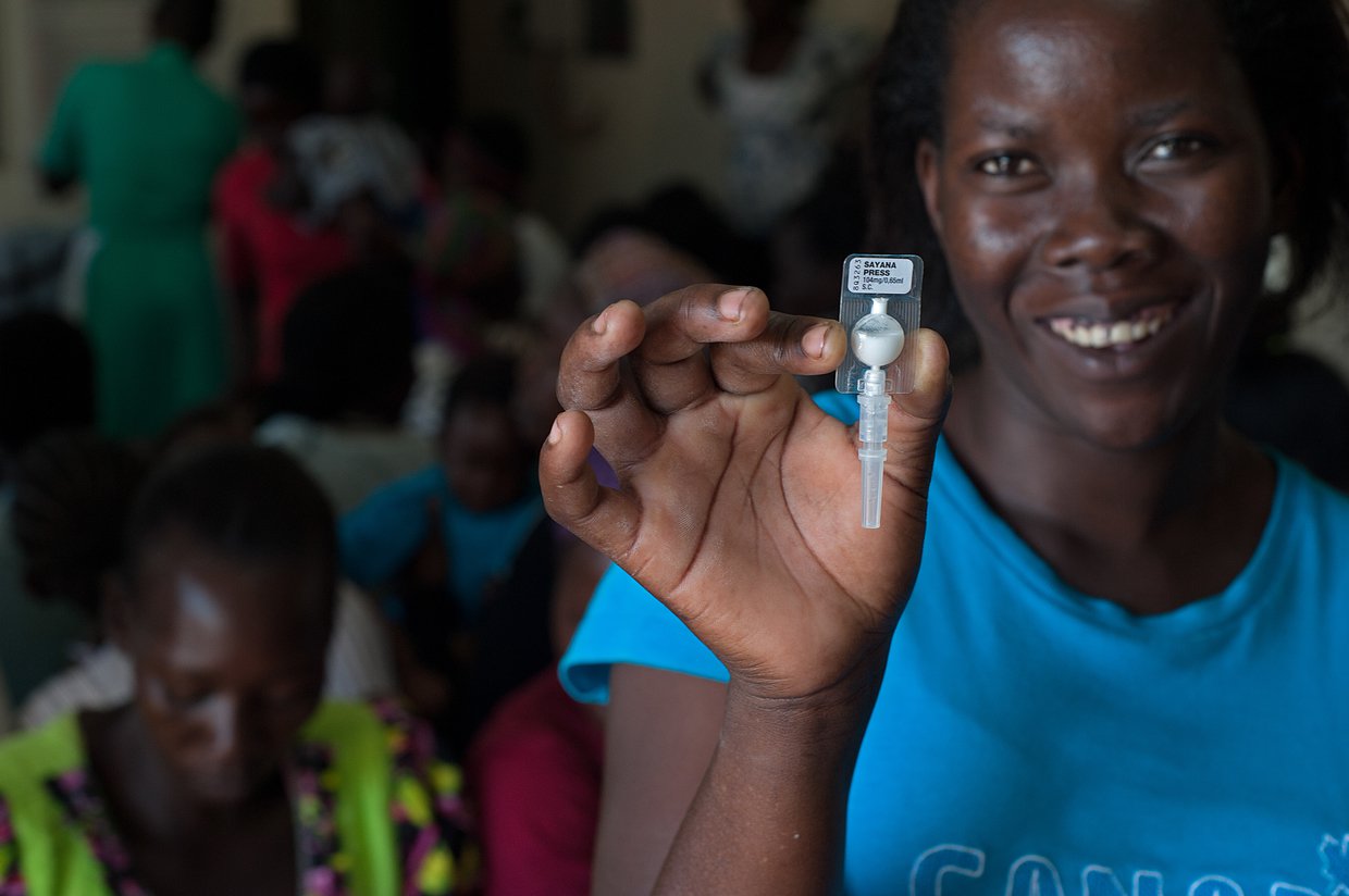 A woman holds a unit of Sayana Press in her hand.