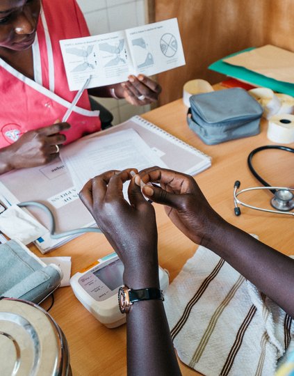 Aminata Gaye, 29, (in pink) explains to Mossan Faye, 21, how to self-inject the contraceptive Sayana® Press at the Dominique Health Center in Pikine, Senegal. PATH/Gabe Bienczycki.