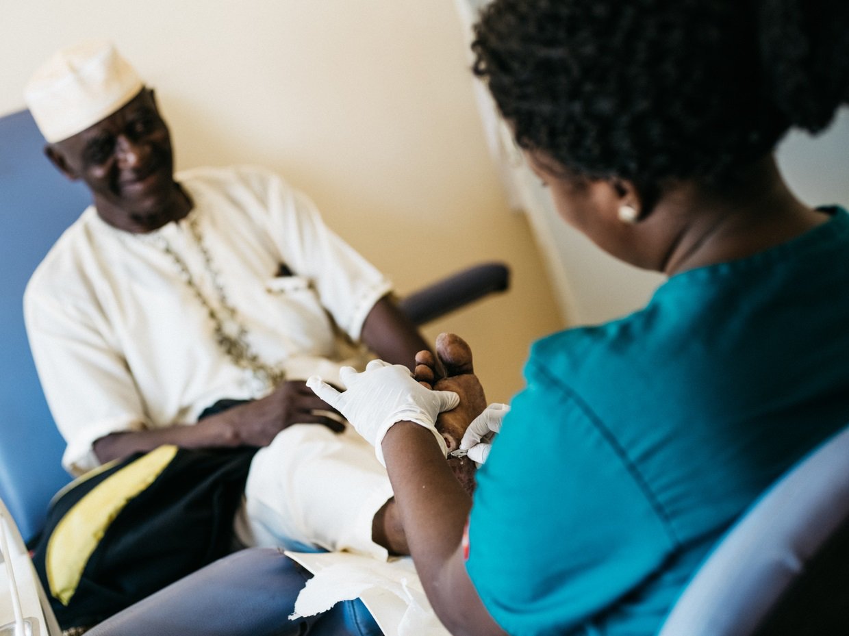 A diabetes patient gets treatment for a foot wound from a healthcare worker.