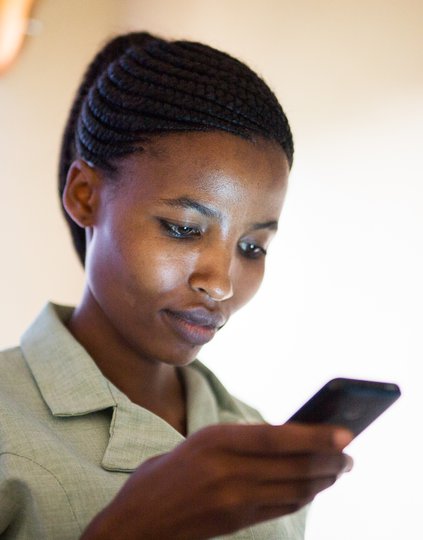 _T9C0873.jpg A woman in Africa looks at her mobile phone.