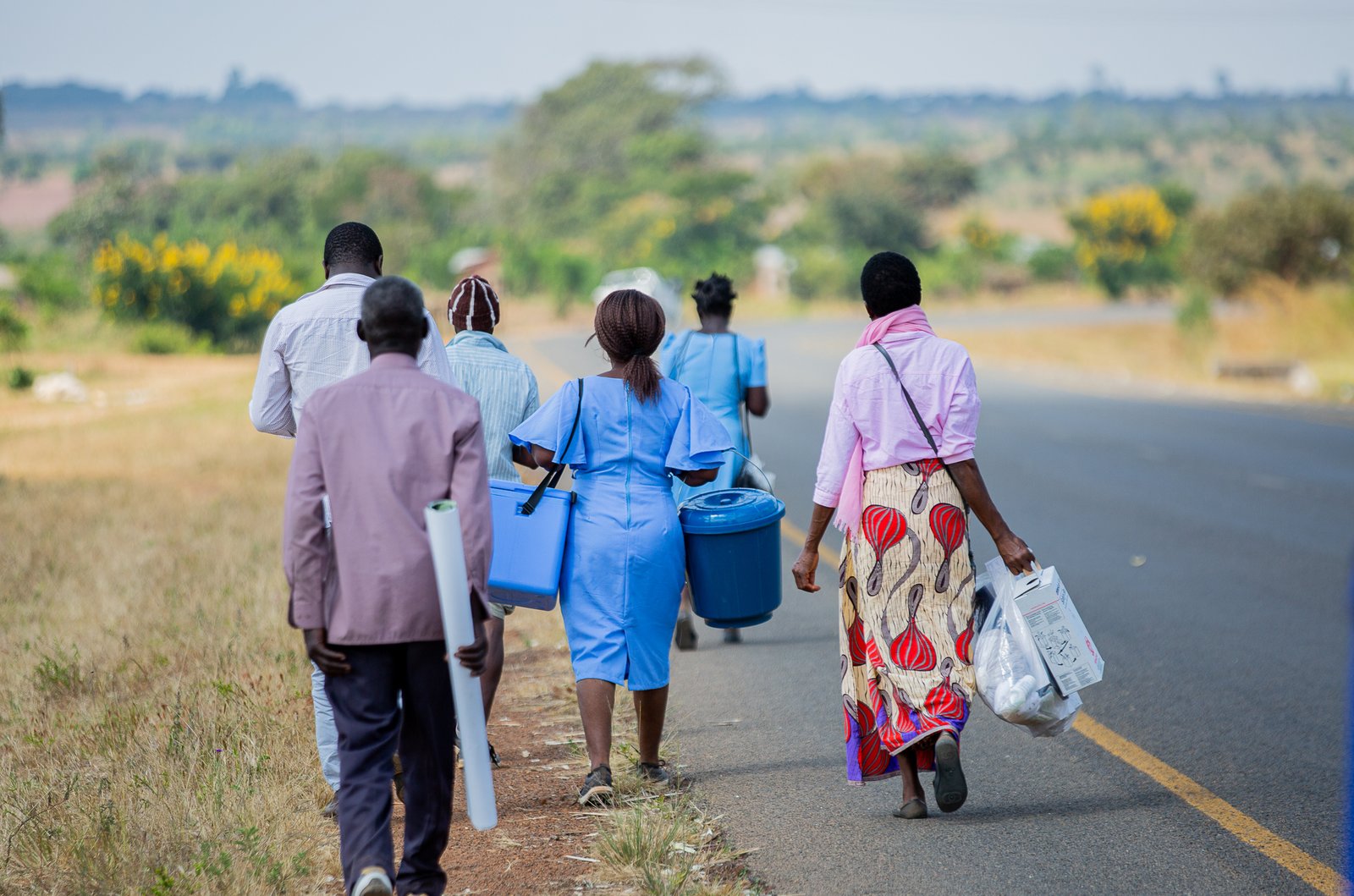 Health surveillance assistants from Nsalu Health Centre walk to Phanga   Village carrying vaccines and supplies for a mobile vaccination site during Malawi’s typhoid conjugate vaccine campaign. Photo: PATH/Madalitso Mvula.