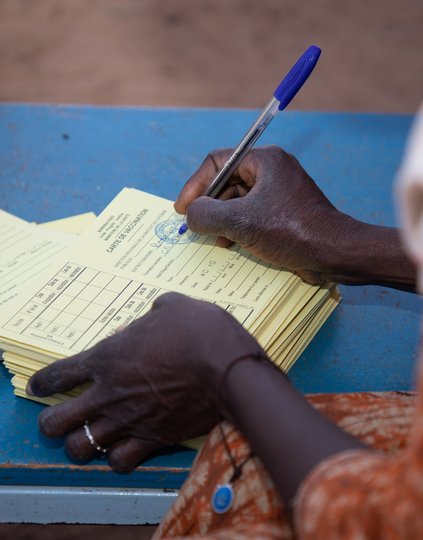 A health care worker prepares vaccination cards for Burkina Faso's TCV introduction campaign. Photo: PATH/Build Africa Communications.