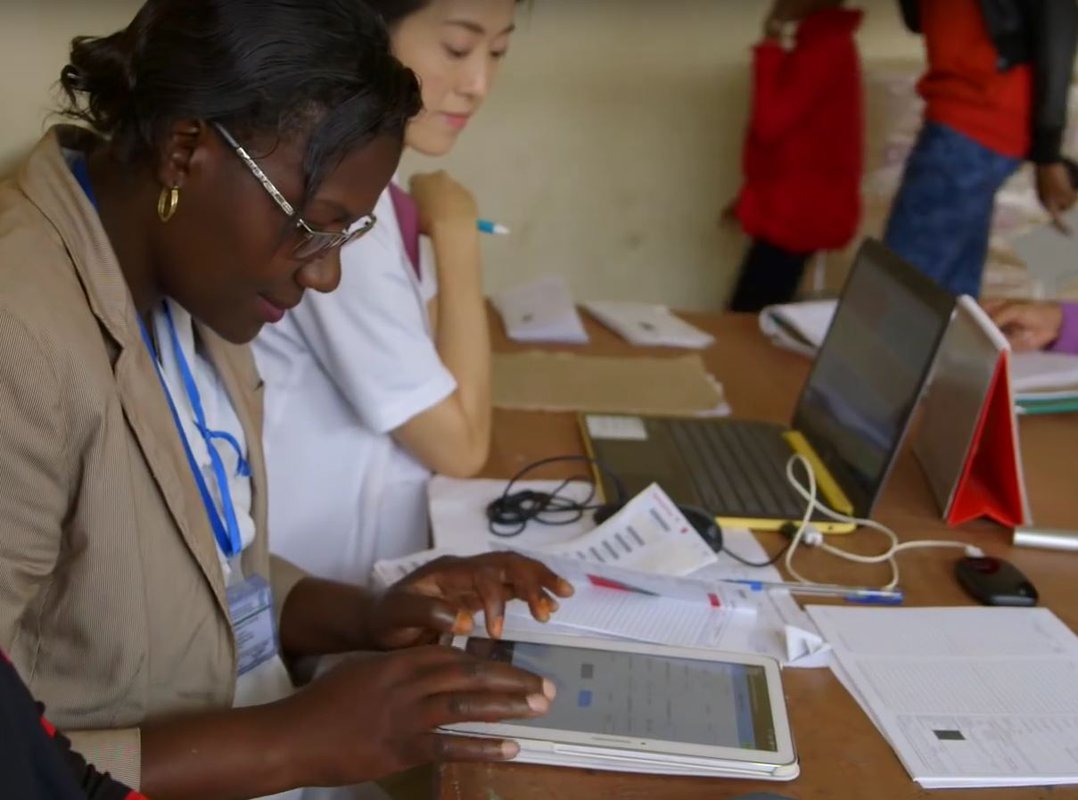 A health care worker uses a tablet to record medical data.