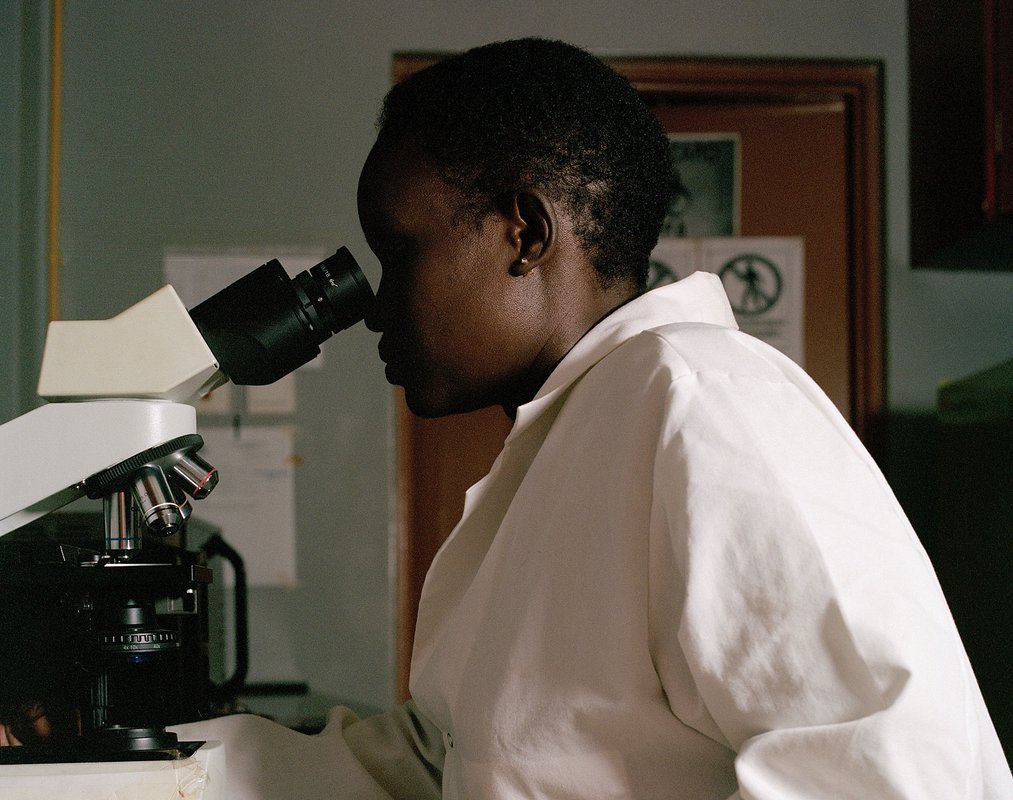 Dr. Laura Lydia Adong, a veterinary officer in Uganda’s Mbale District, examines blood samples taken from local farm animals. Photo: PATH/BBC StoryWorks.