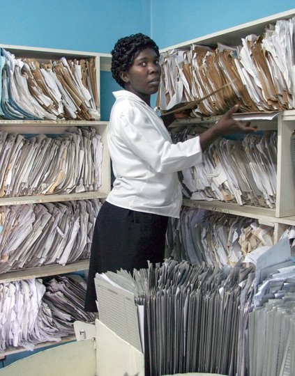 A medical practitioner in Kenya searches for a health record in a data room in a national health facility. Photo: PATH.