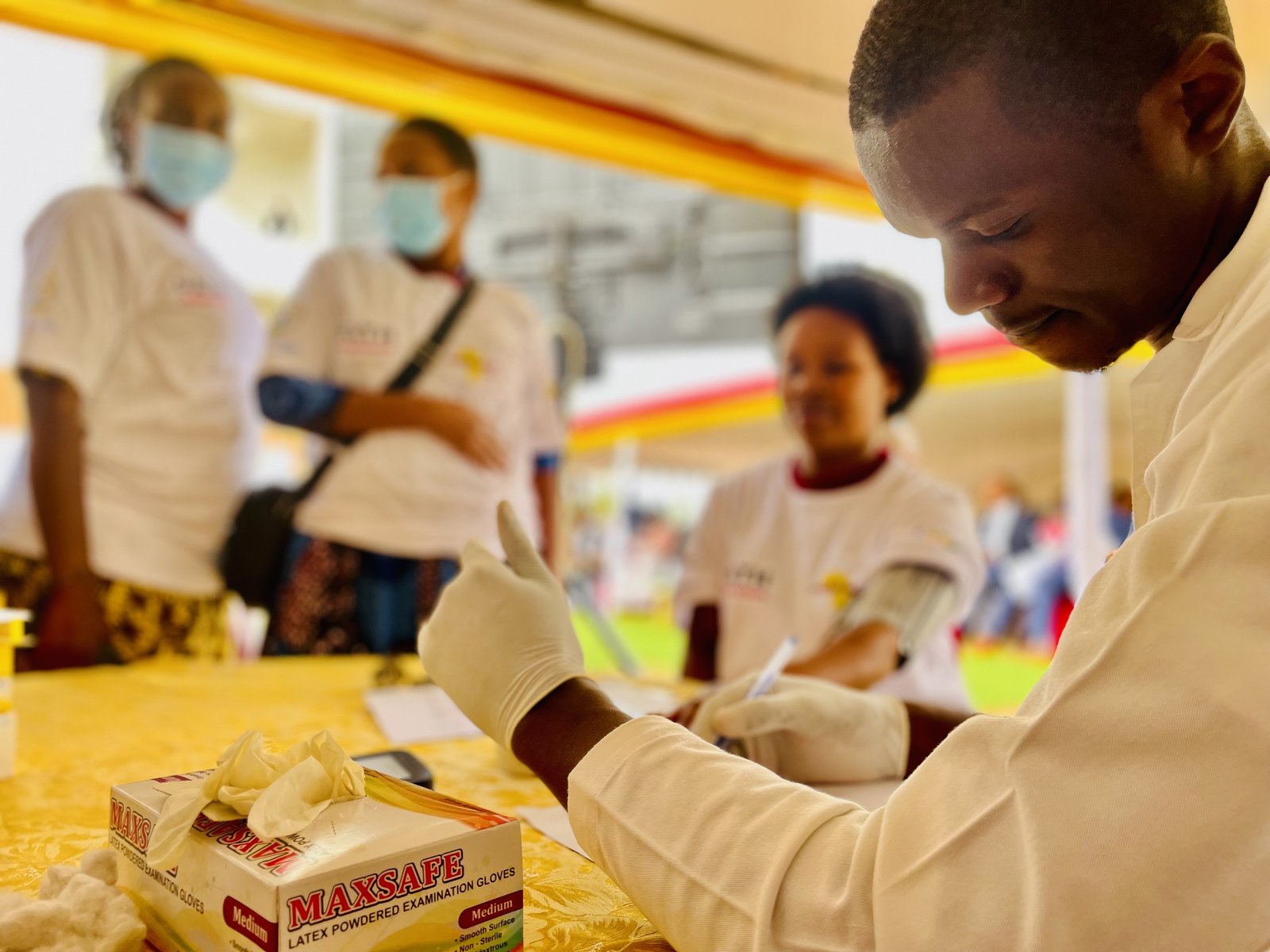 A health provider records hypertension measurements during a community health activity organized by PATH. Photo: PATH/Charles Wanga