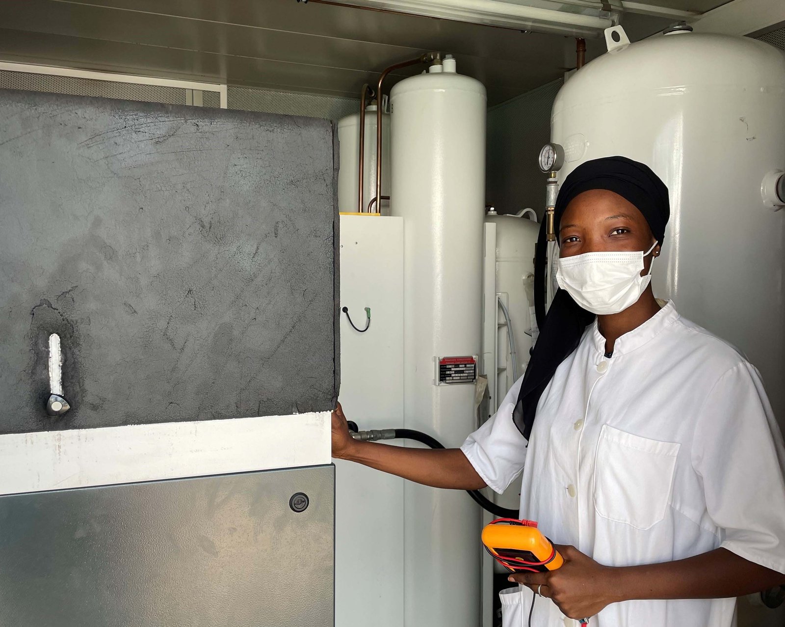 A biomedical engineer in Senegal services a pressure swing adsorption oxygen generation plant. Photo: PATH/Conner House.