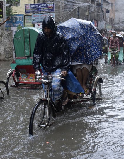 Rickshaw pullers on a flooded street in Dhaka, Bangladesh. Climate change is changing the way we look at everything—including health systems.  Photo: Sk Hasan Ali.