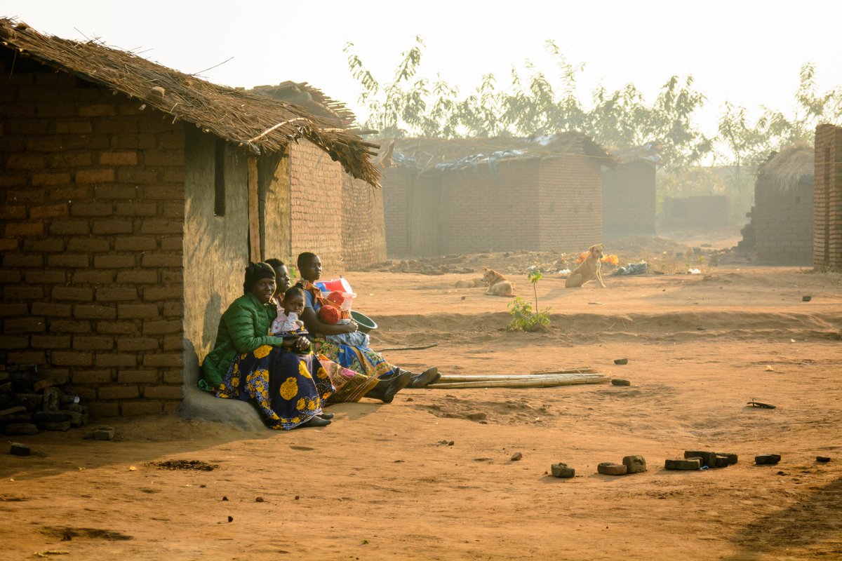 Women hold their babies in front of their homes in Lilongwe, Malawi. Editorial credit: Julian Lott / Shutterstock.com.