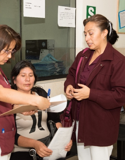 Professional midwife Katya Ulco (left), patient Luzberta Rodriguez (center), and Cancer Coordinator Rosa Gonzalez (right) discuss Luzberta’s care at a clinic in Peru (photo taken prior to COVID-19 pandemic). Photo: PATH/Daniel San Martin.